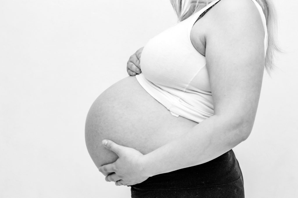 Czarno-białe zdjęcie brzuszka kobiety w ciąży
